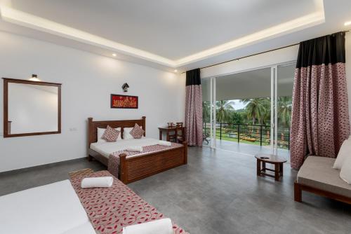 a bedroom with a bed and a couch at Tara Watergate in Tissamaharama