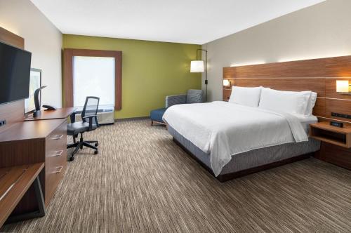 a hotel room with a bed and a flat screen tv at Holiday Inn Express Statesboro by IHG in Statesboro
