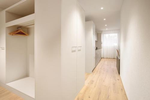a hallway with white walls and a hard wood floor at Ferienwohnungen Tannenboden in Flumserberg