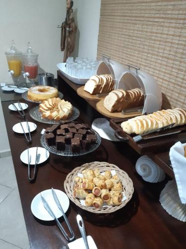 a table topped with different types of bread and pastries at Hotel Casarão Pitangueiras in Guarujá