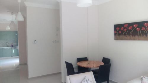 a dining room with a table and chairs and a painting at Aqua Royal Alexus Luxury Holiday Apartments Girne in Kérynia