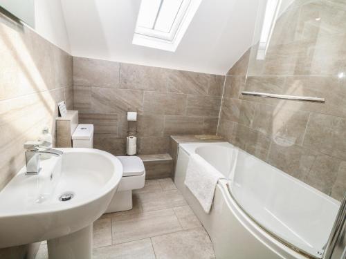 łazienka z umywalką, wanną i toaletą w obiekcie Broadwood Barn w mieście Hathersage