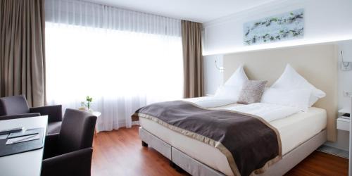a bedroom with a bed and a desk in a room at Hotel Hangelar in Sankt Augustin