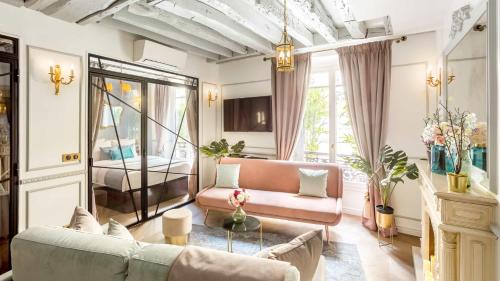 ein Wohnzimmer mit einem Sofa und einem Tisch in der Unterkunft Luxury 4 bedroom 3 bathroom Aristocratic apartment - Louvre in Paris