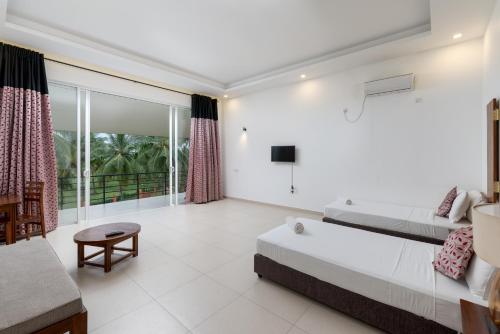 a large living room with a bed and a couch at Tara Watergate in Tissamaharama