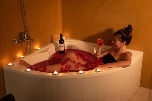 a woman sitting in a bath tub with a glass of wine at Tara Watergate in Tissamaharama