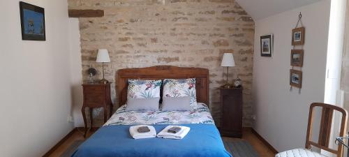 a bedroom with a bed with two shoes on it at La Maison de l'Escargot in Seigny