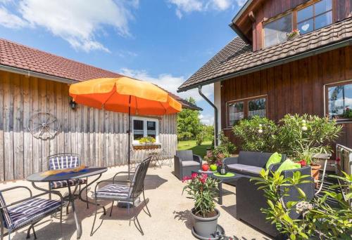 a patio with a table and chairs and an umbrella at Ferienwohnung Obstwiese in Hergensweiler