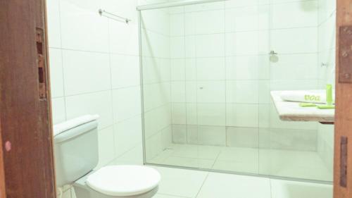 a bathroom with a shower with a toilet and a sink at Pousada Porto Da Barra in Porto Seguro