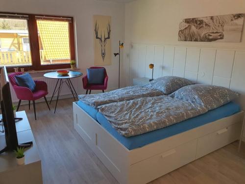 a bed in a room with chairs and a table at Simone's Ferienwohnung am Plöner See in Bosau