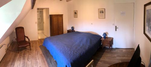 a bedroom with a blue bed and a staircase at Chambres d'hôtes Domaine De La Jonquière, Bouloire in Bouloire