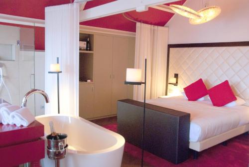 a bedroom with a tub and a bed and a bath tub at Hotel Spaander BW Signature Collection in Volendam