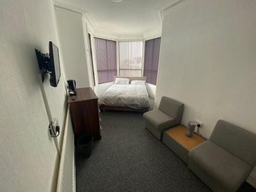 a small room with a bed and a chair at The Honley hotel in Blackpool