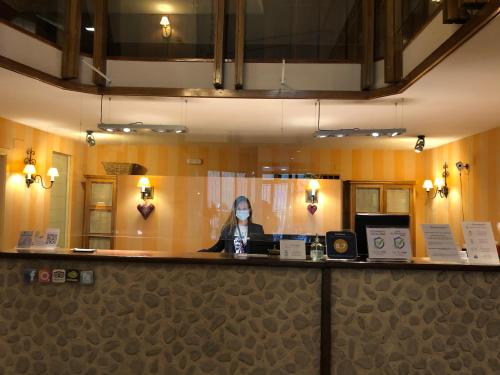 a woman sitting at a bar in a restaurant at Hotel Edelweiss Candanchú in Candanchú