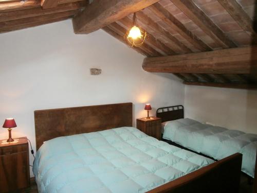 1 dormitorio con 1 cama grande y 2 mesitas de noche en Antico Fienile, en Serravalle