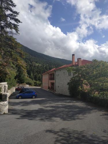 um carro estacionado num parque de estacionamento ao lado de um edifício em Vytina Mountain View Hotel em Vytina