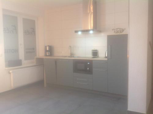 a white kitchen with a sink and a microwave at Hotel Restaurant Fritz in Gronau