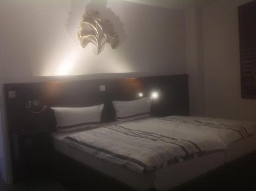 a bedroom with a bed with lights on the wall at Hotel Restaurant Fritz in Gronau