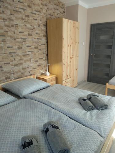 sypialnia z dwoma łóżkami i ceglaną ścianą w obiekcie Penzion U Splavu w mieście Loket