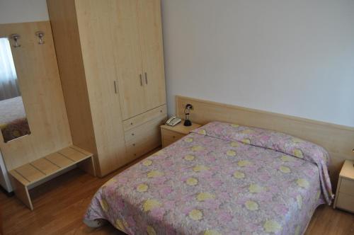 a small bedroom with a bed and a dresser at Hotel Piol in Limana