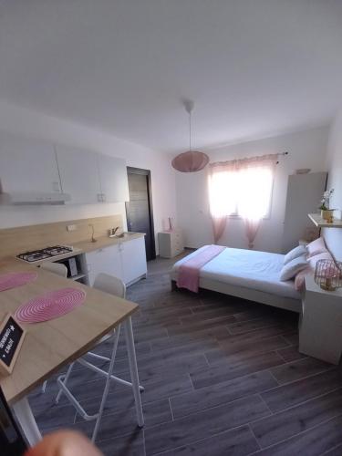 ein Schlafzimmer mit einem Bett und eine Küche mit einem Tisch in der Unterkunft DIMENTICA IL CERVELLO in Palermo