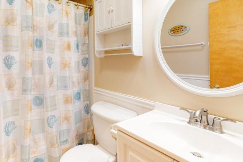 a bathroom with a toilet and a sink and a mirror at Breakers #12-FF in Frisco
