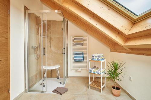 a bathroom with a shower with a chair and a stool at Ferienhof Halbig in Riedenburg