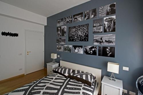 a bedroom with a blue wall with pictures on it at The Photos Room B&B in Rome
