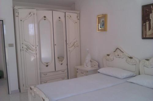 1 dormitorio con 2 camas y un gran armario blanco en Villa Rustica, en Nardò