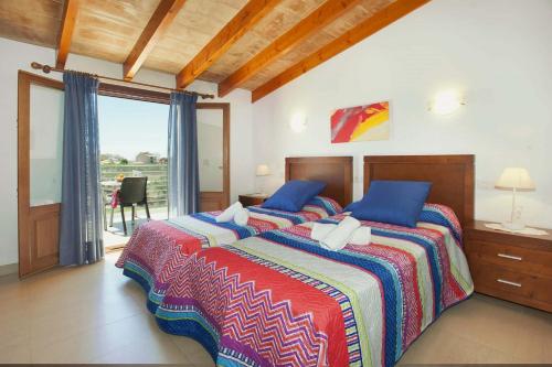 ein Schlafzimmer mit einem großen Bett mit blauen Kissen in der Unterkunft Villa La Rovina in Alcúdia