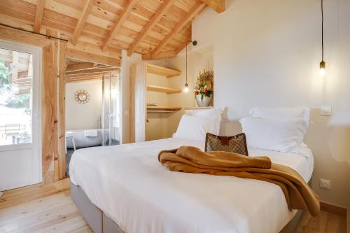 sypialnia z białym łóżkiem z ręcznikiem w obiekcie Villa Mimbeau w mieście Cap-Ferret