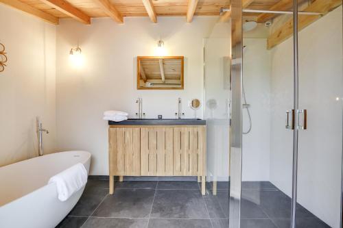 ein Badezimmer mit einer Badewanne und einem Waschbecken in der Unterkunft Villa Mimbeau in Cap-Ferret
