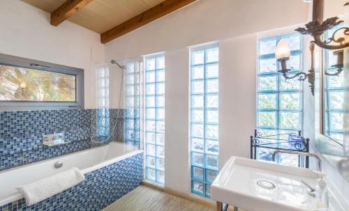 y baño con bañera, lavabo y ventanas. en Pool House en Palma de Mallorca