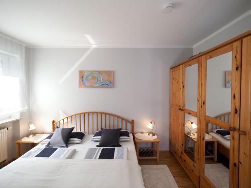 a bedroom with two beds and a wooden cabinet at Ferienwohnung Garzmann in Bad Reichenhall