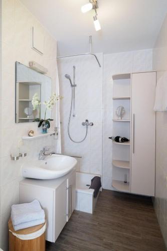 a white bathroom with a sink and a shower at Ferienwohnung Garzmann in Bad Reichenhall