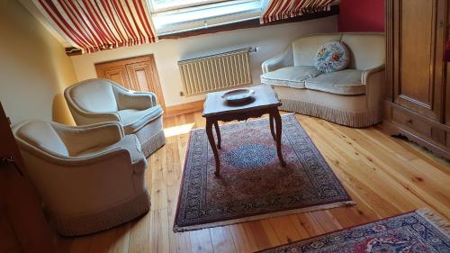 a living room with two chairs and a table at Le Prangeleux in Tenneville
