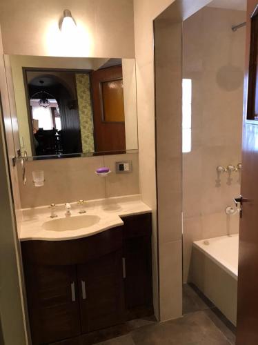 a bathroom with a sink and a tub and a mirror at SWEET HOME PATAGONIA in Comodoro Rivadavia