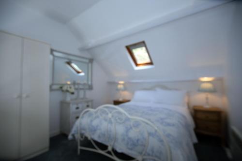 a bedroom with a bed and two lights on the ceiling at Charming 1-Bed cottage in Pembroke close to castle in Pembroke