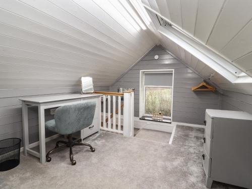 an attic office with a desk and a window at Wagtail in Tarporley