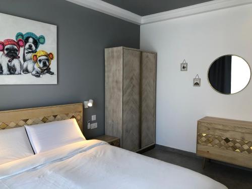 a bedroom with a bed and a painting of dogs at Apartments by Sliema promenade and beach in Sliema