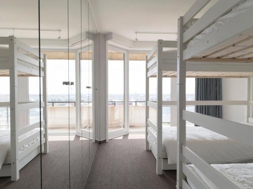 1 Schlafzimmer mit 2 Etagenbetten und Glasfenstern in der Unterkunft zzzee Nieuwpoort in Nieuwpoort