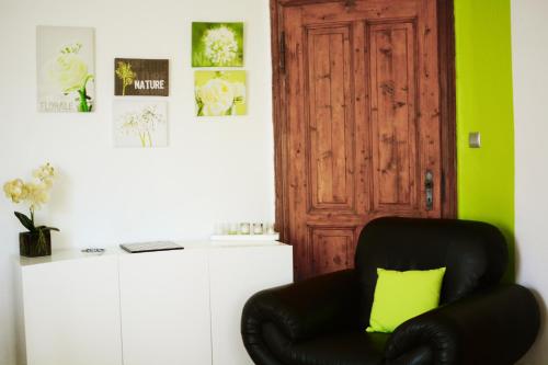 a black chair with a yellow pillow in front of a door at le gite d'Eliane in Masevaux