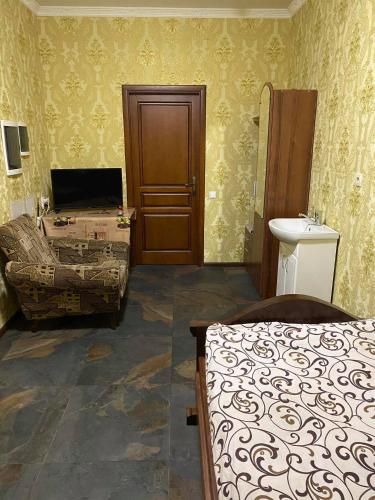 a bedroom with a bed and a sink and a door at Готель-ГАЙСИН-Ресторан in Haysyn