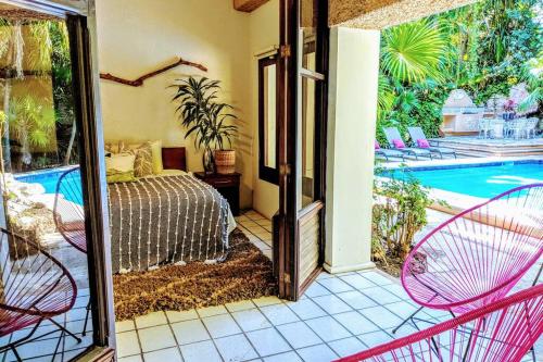 a bedroom with a bed and a swimming pool at Steps to Ocean Huge Beach Villa Private Pool in Exclusive Fase 1 Playacar in Playa del Carmen