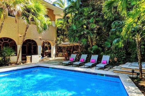 a pool with chairs and a house with palm trees at Steps to Ocean Huge Beach Villa Private Pool in Exclusive Fase 1 Playacar in Playa del Carmen