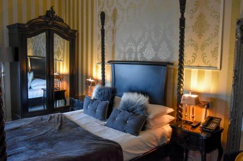 a bedroom with a large bed and a mirror at The Hotel Commodore in Llandrindod Wells