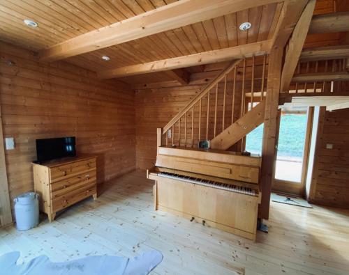 Zirbitz Hütte mit Sauna und Kamin في سانكت لامبريتشت: غرفة كبيرة فيها بيانو وسقف خشبي