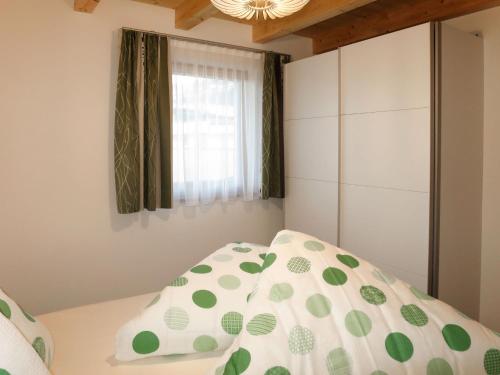 a bedroom with a bed with a pillow and a window at Apartment Nina by Interhome in Uderns
