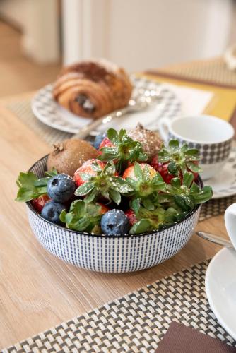 a salad in a bowl on a table at Fervore Luxury Rooms in Palermo