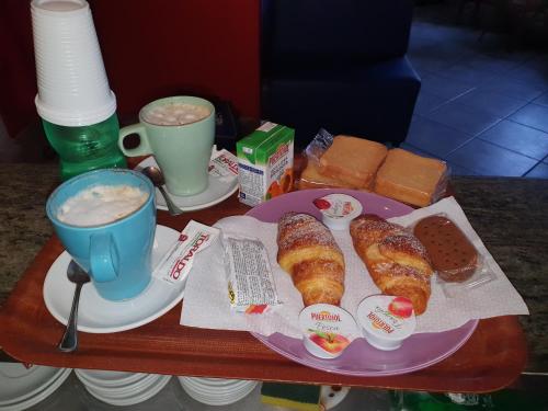 a tray with a plate of food and coffee and pastries at Hotel Caribe in Casalnuovo di Napoli